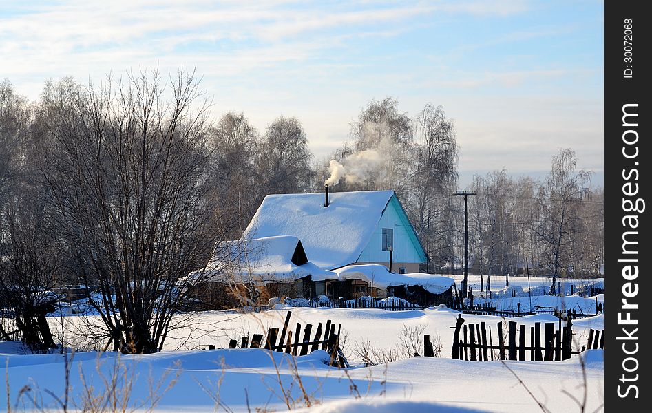 Small house in the village is covered with white snow