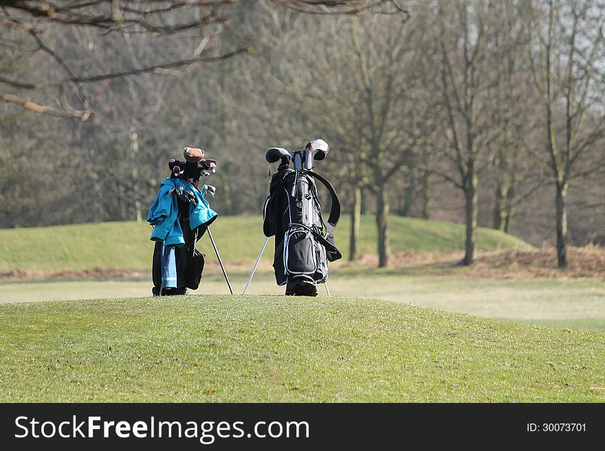 Two Golf Bags Standing During a Golfing Round. Two Golf Bags Standing During a Golfing Round.
