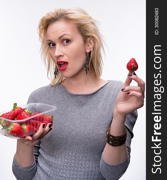 Young happy blond girl with fresh strawberries on a white background