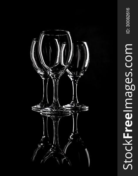 Set of three clean and empty wineglasses and reflection. Selective focus. Shot in studio. Set of three clean and empty wineglasses and reflection. Selective focus. Shot in studio.