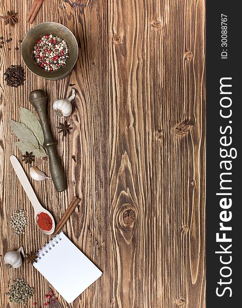Spices and notepads on a wooden background. Spices and notepads on a wooden background