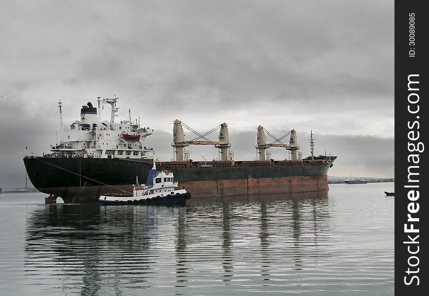 Tug boat towing bulk carrier vessel.