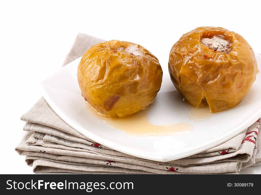 Baked apples in a white plate standing on napkins