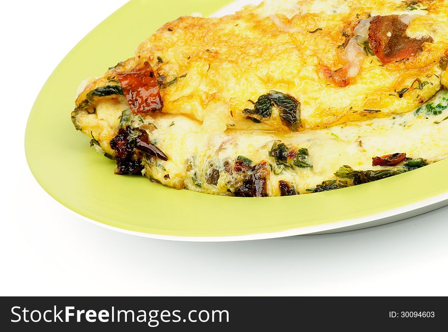 Delicious Omelet with Tomatoes, Parsley, Leek and Dill on Green Plate closeup. Delicious Omelet with Tomatoes, Parsley, Leek and Dill on Green Plate closeup