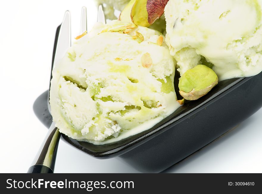 Two Balls of Pistachio Ice Cream in Black Plate with Dessert Fork closeup