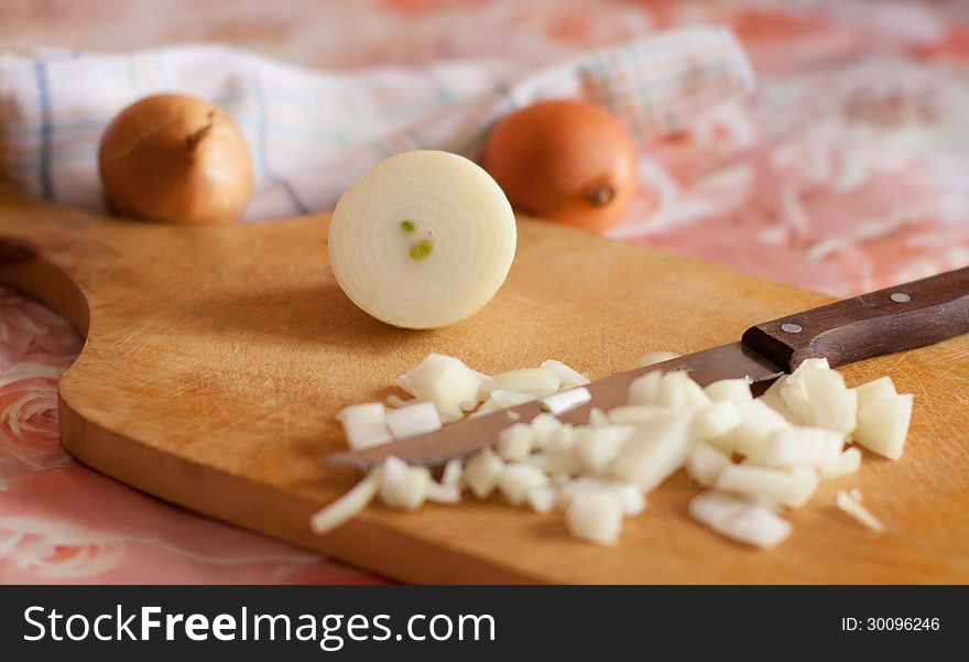 Chopped onions on a kitchen board and knife. Chopped onions on a kitchen board and knife