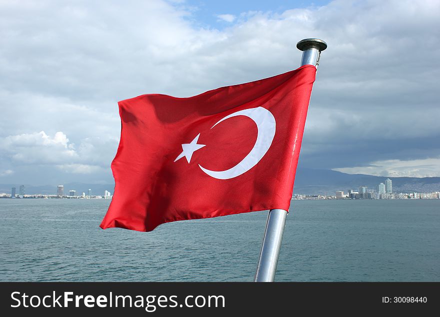 Turkey flag with metal shaft on Izmir bay background. Turkey flag with metal shaft on Izmir bay background