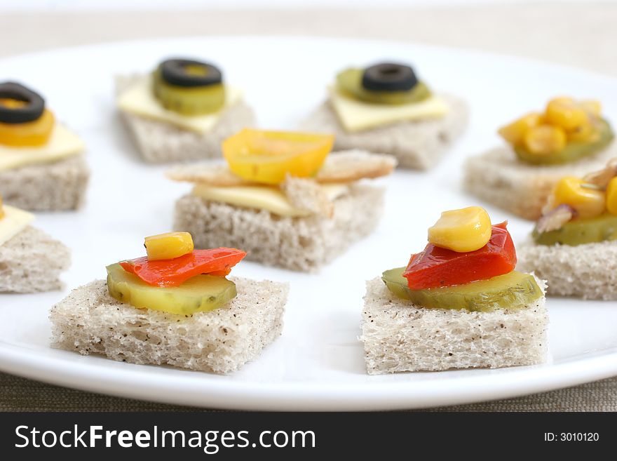 Fruit and vegetable canapes on a white ceramic plate. Fruit and vegetable canapes on a white ceramic plate