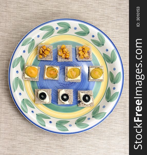 Fruit and vegetable canapes arranged as a face on a small plate. Fruit and vegetable canapes arranged as a face on a small plate