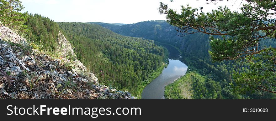 The river flows between mountains, ostium, forest, altitude, far, panorama. The river flows between mountains, ostium, forest, altitude, far, panorama