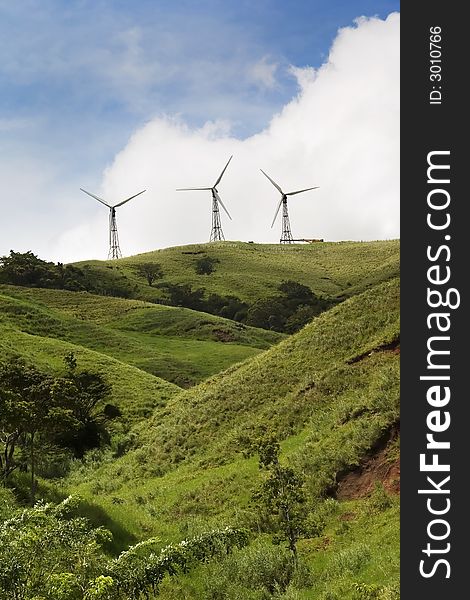 Three energy generating windmills on a green hilltop. Three energy generating windmills on a green hilltop.