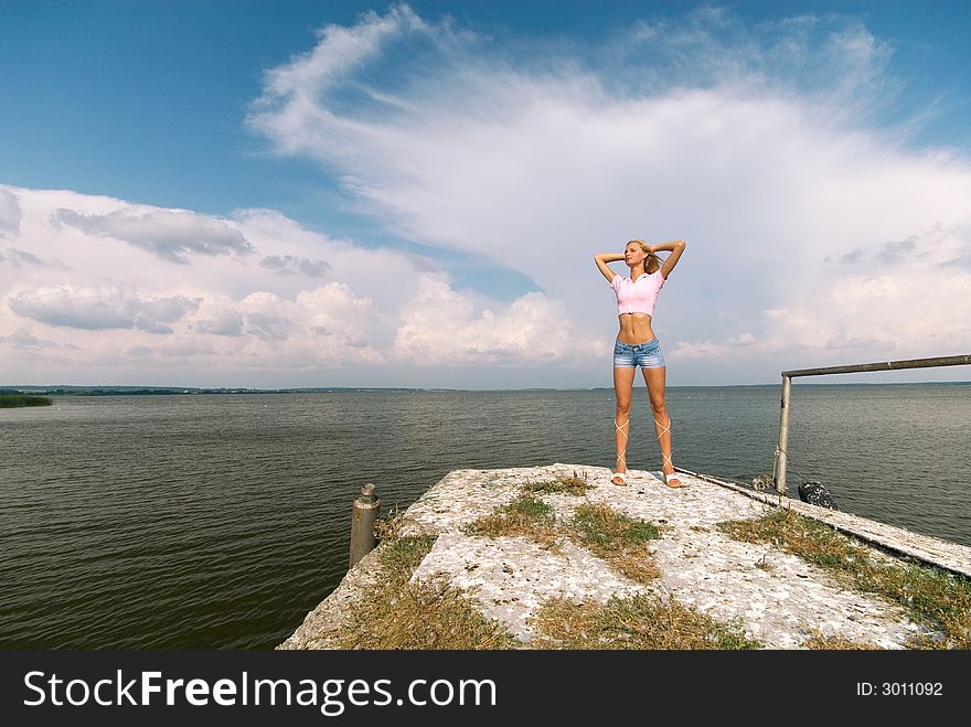 The young beautiful woman stands on seacoast. The young beautiful woman stands on seacoast