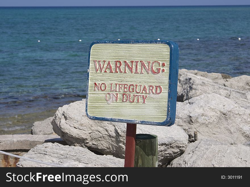 Warning sign on an isolated beach in the Caribbean. Warning sign on an isolated beach in the Caribbean.