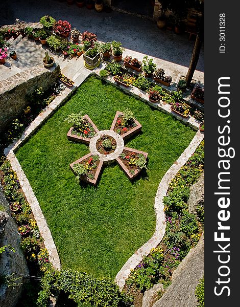 Garden, grass and flowers, cross, monastery in Meteora, Greece