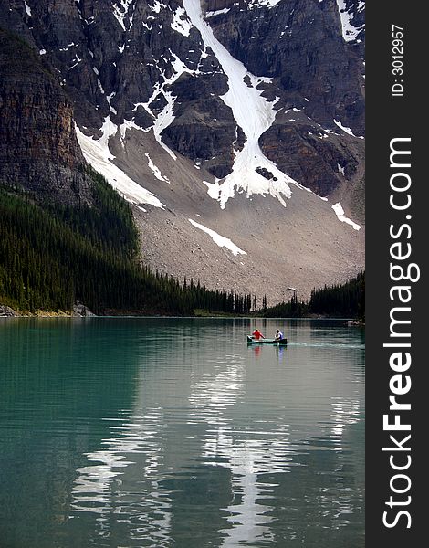 Active people in a canoe on a mountain lake. Active people in a canoe on a mountain lake.