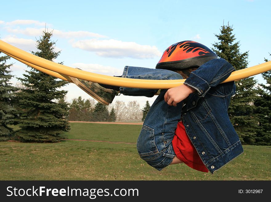 Young boy hanging on playground equipment. Young boy hanging on playground equipment.