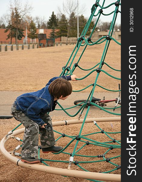 Young boy playing in a playground.