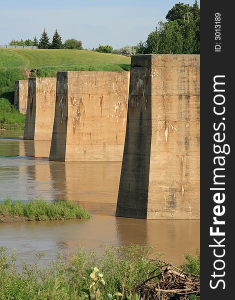 Abandoned railway bridge pilings lined up across a river. Abandoned railway bridge pilings lined up across a river.