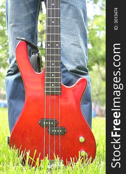 Red Bass Guitar On The Grass