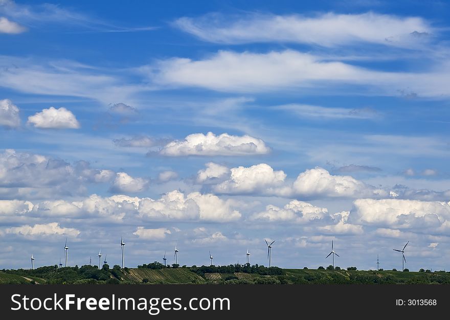 Many wind engines in front of a dynamic sky