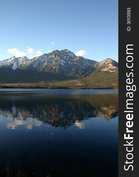 Mountain reflection and a still crystal blue lake.