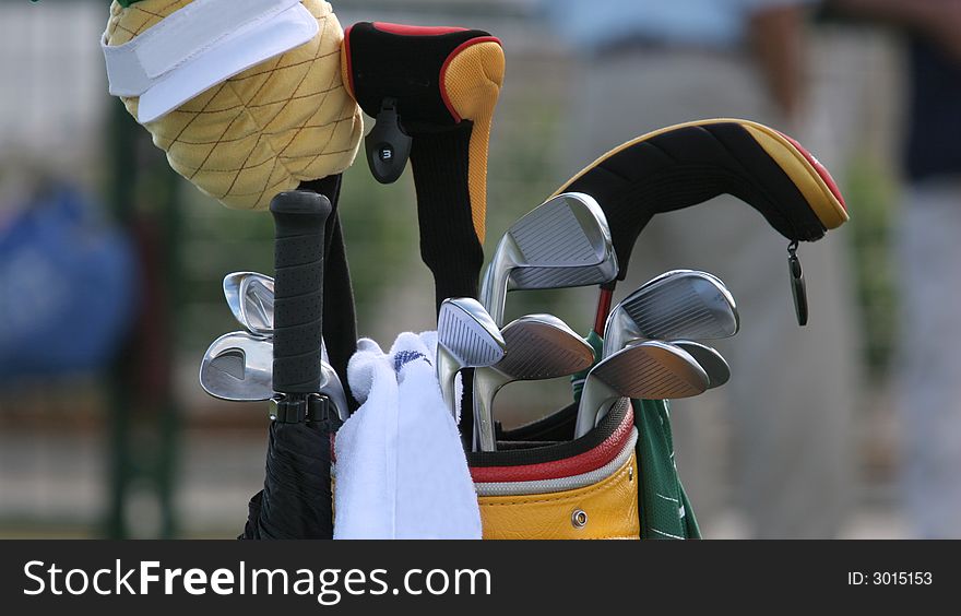 Golf bag and set of clubs on green