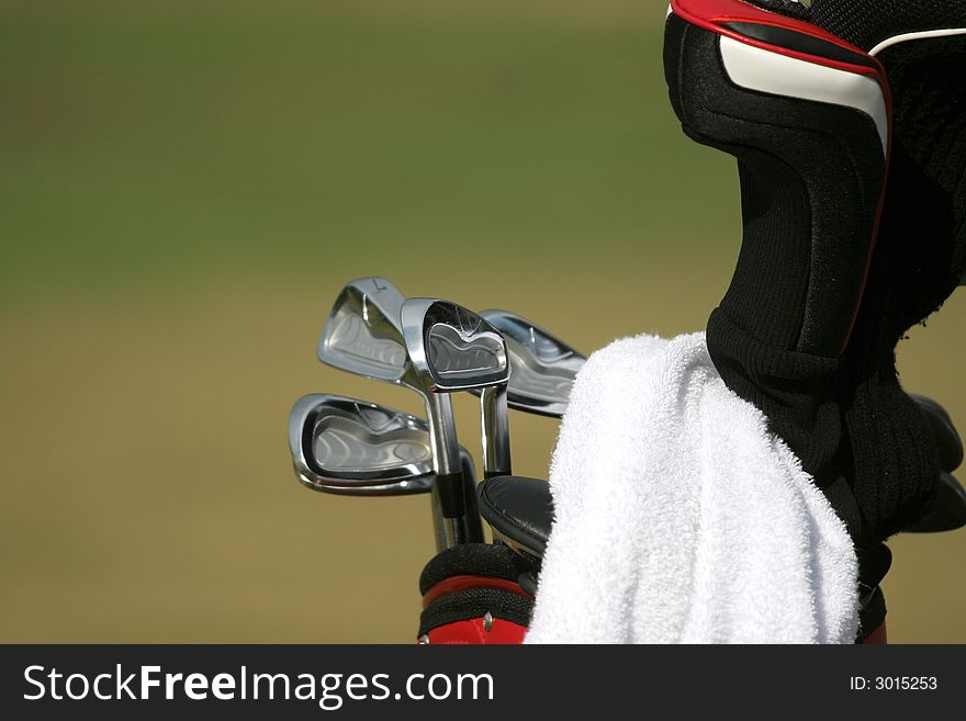 Golf bag and set of clubs on green