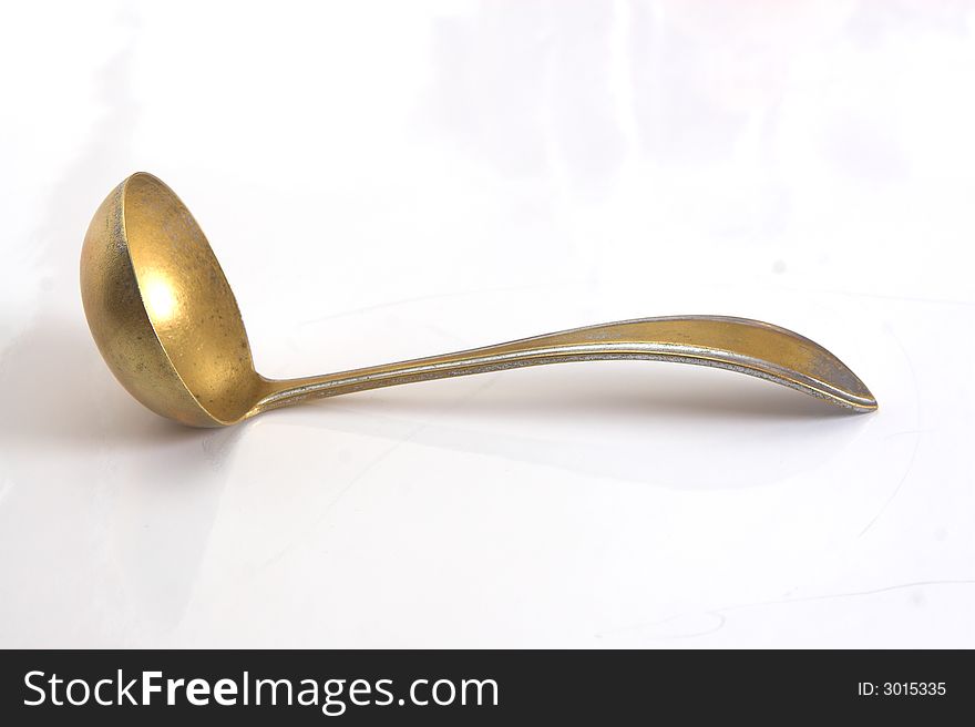 Ancient brass soup spoon isolated on white