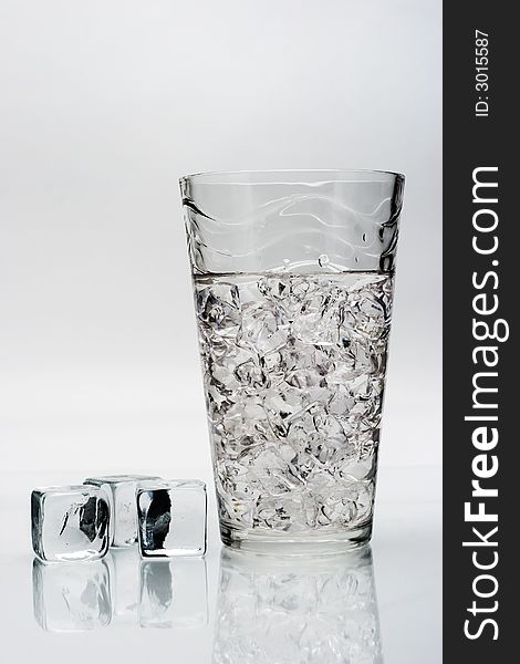 A glass with crashed ice and ice cubes isolated on white background. A glass with crashed ice and ice cubes isolated on white background