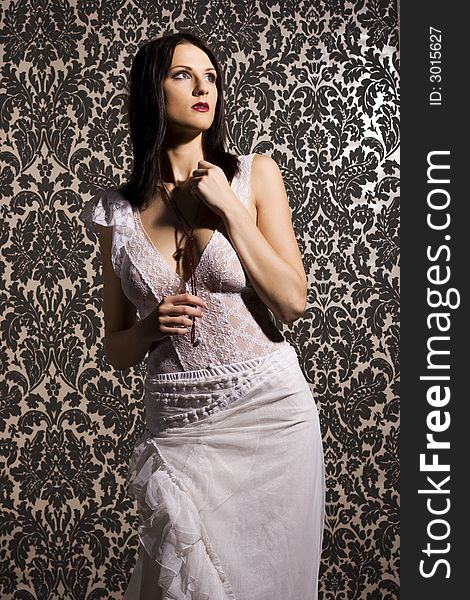 Beautiful brunette woman wearing white blouse and skirt on background with pattern