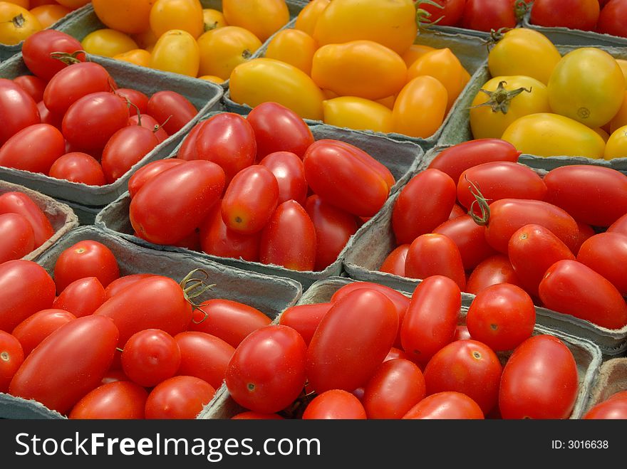 A display of red and yellow plum tomatoes at an outdoor market in Ottawa, Canada. A display of red and yellow plum tomatoes at an outdoor market in Ottawa, Canada