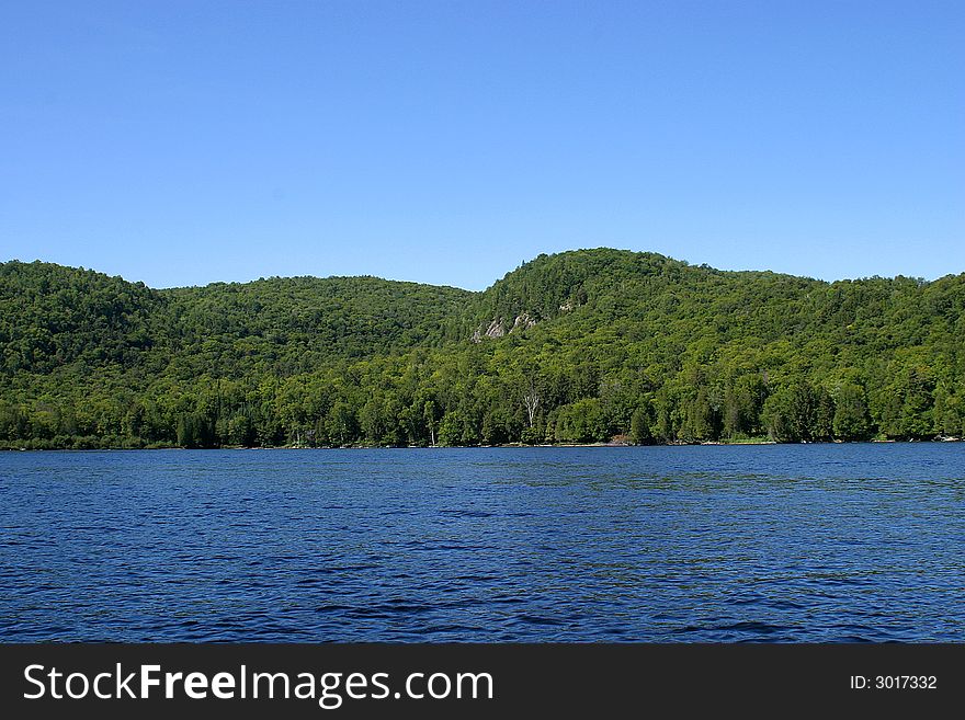 Green hills with blue sky form the lake