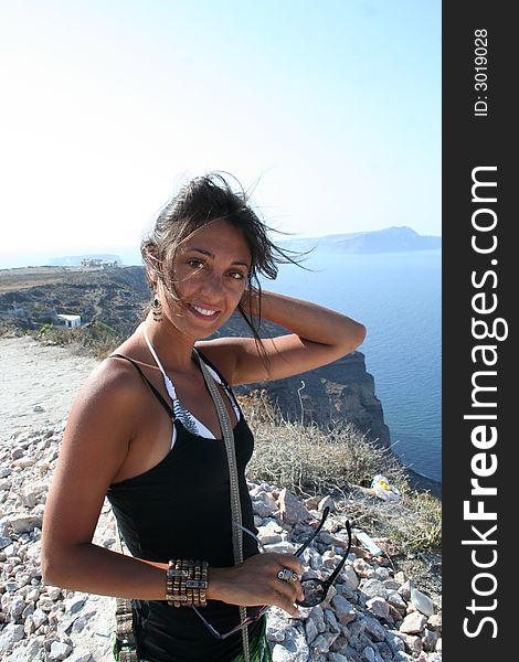 Happy Girl hear a rock in Greece Santorini Greece. Happy Girl hear a rock in Greece Santorini Greece