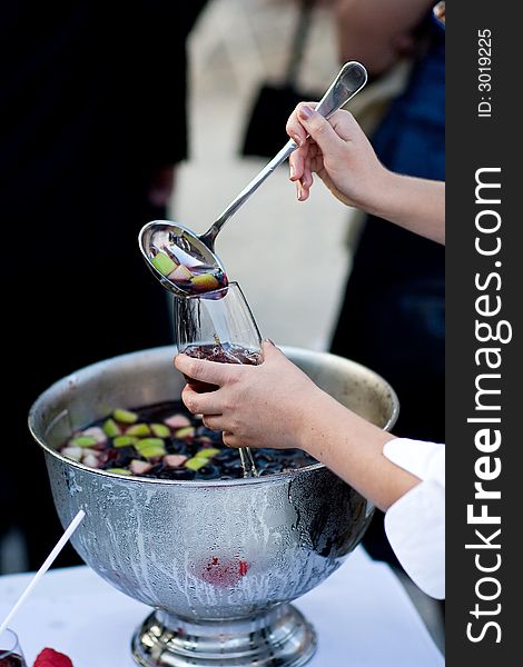 Refreshing cold Wine cooler with fruitpieces. Someone pours it into a glass. Refreshing cold Wine cooler with fruitpieces. Someone pours it into a glass.