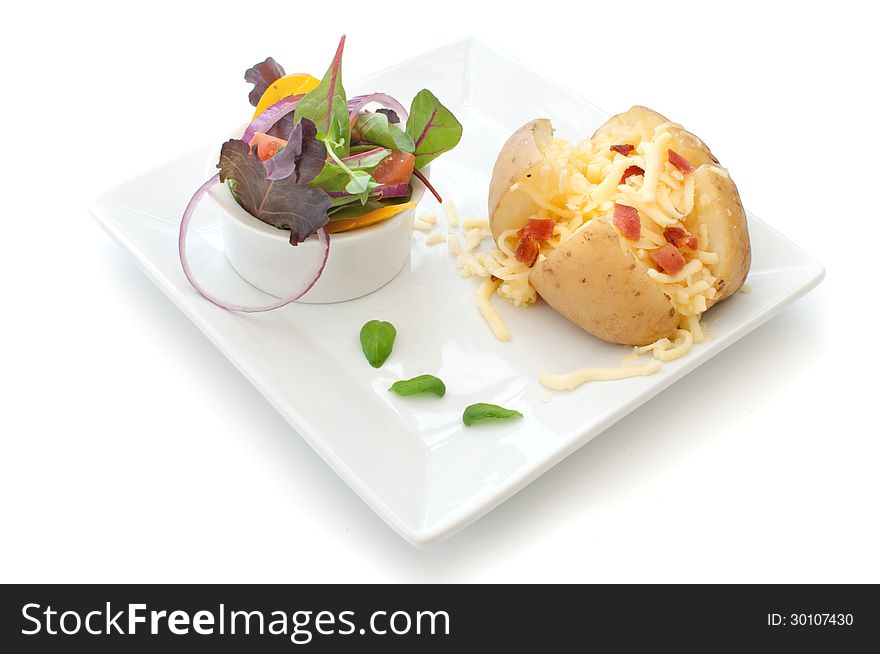 Grated cheese and bacon pieces with baked potato over a white background. Grated cheese and bacon pieces with baked potato over a white background