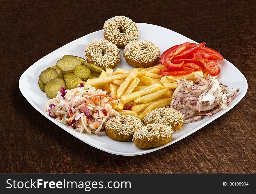 Falafel with french fries and vegetables on a plate