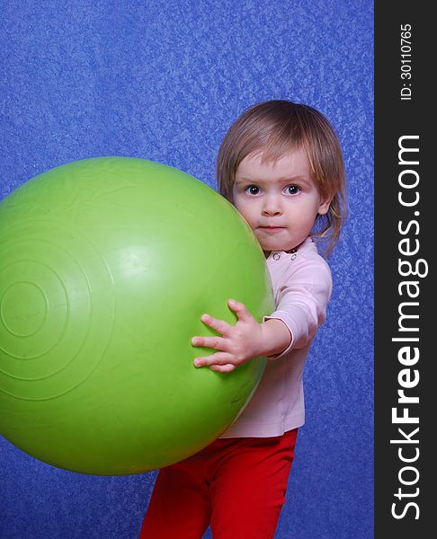 Child with ball, portrait on a blue background. This image has attached release.