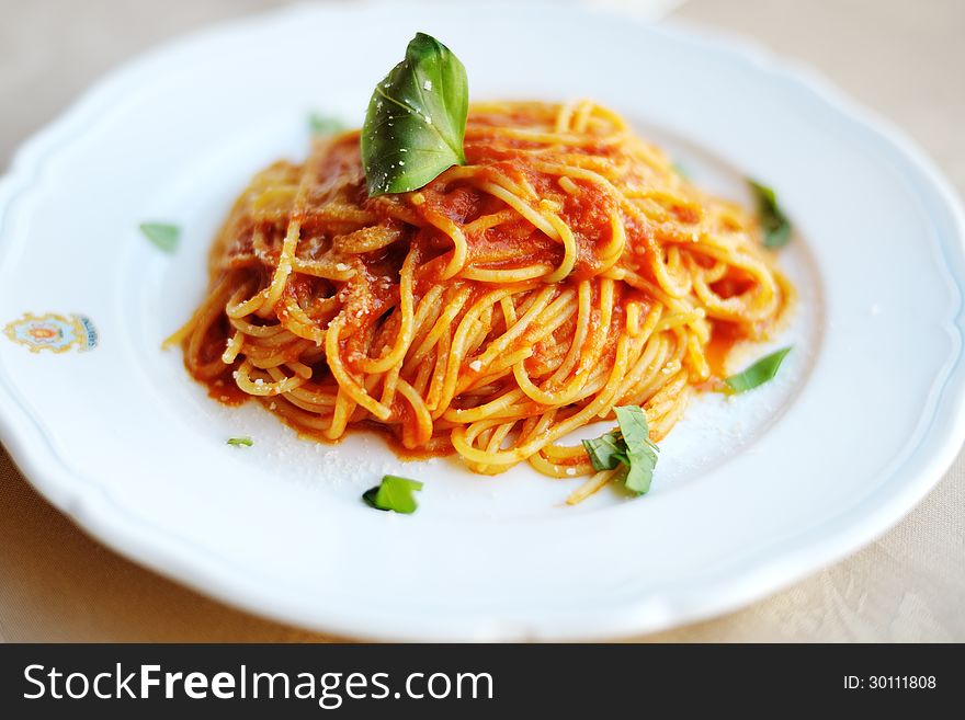 Plate of italian spaghetti with tomato, parmesan and basil