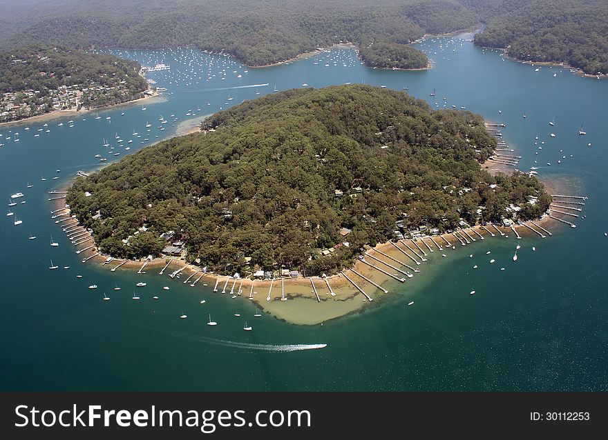 An aerial view of an island near Sydney with many boats moored around it. An aerial view of an island near Sydney with many boats moored around it