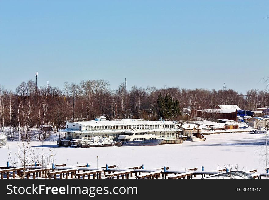 Yachts, boats and river passenger ships in the snow on a winter dock. Yachts, boats and river passenger ships in the snow on a winter dock