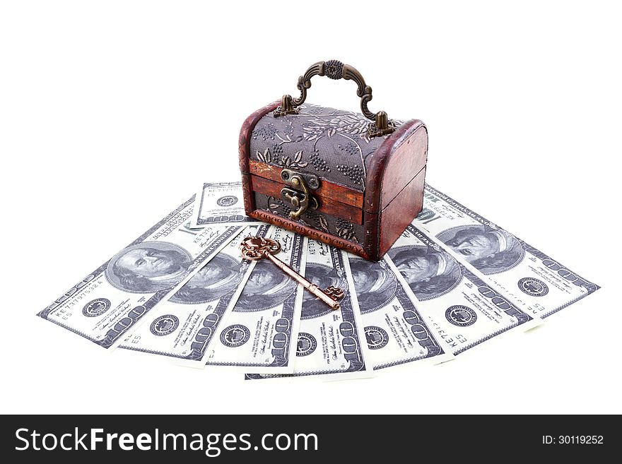 Treasure chest with an old skeleton key upon US paper currency isolated on white. Treasure chest with an old skeleton key upon US paper currency isolated on white.