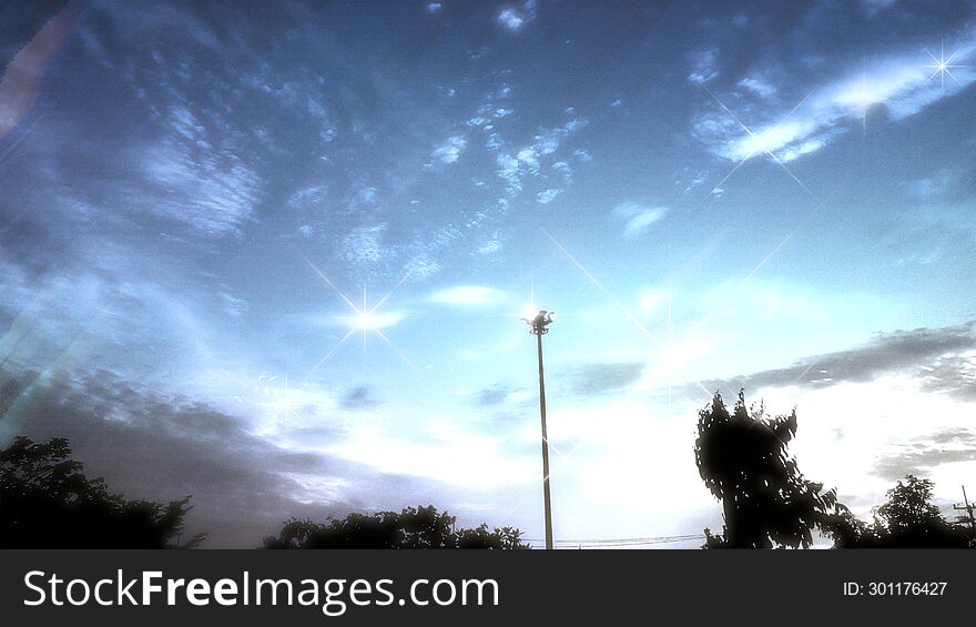 Clear Sparkle Twilight Sky with Light Tower and Tree Peaks, Slightly Clouds