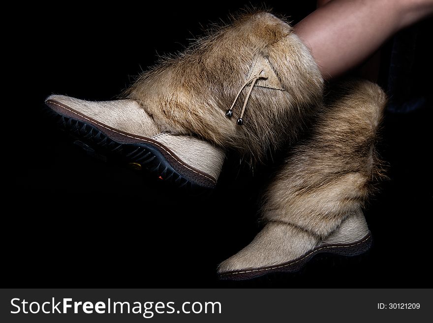 Female winter shoes made of fur. on black background. Female winter shoes made of fur. on black background.