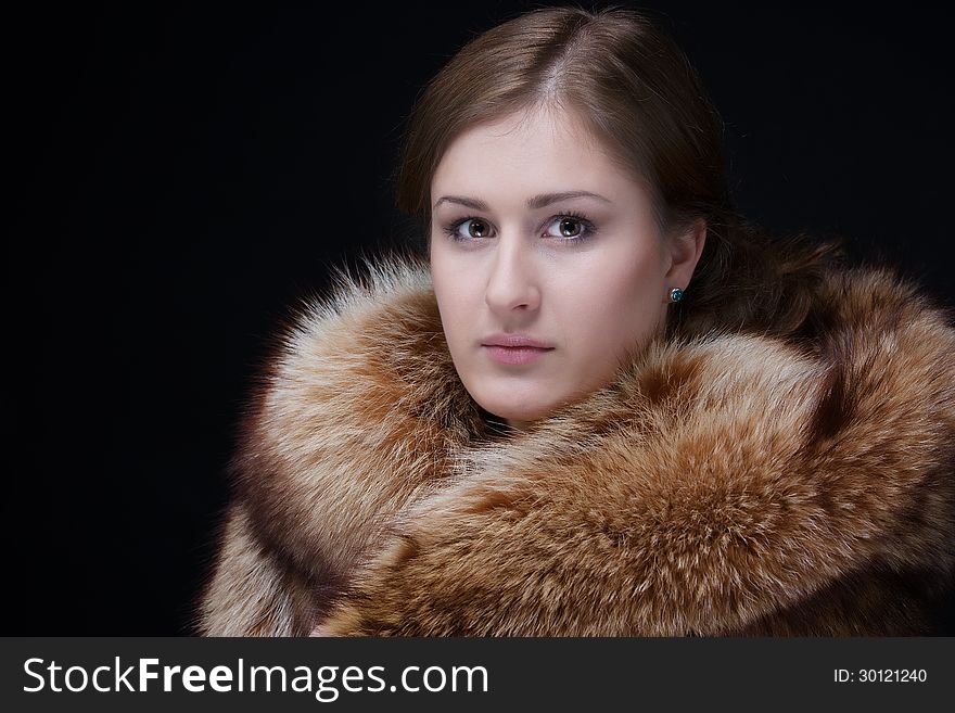 Portrait of beauty lady. Good looking young woman in luxury winter fur mink coat. Shot in studio. on black background. Portrait of beauty lady. Good looking young woman in luxury winter fur mink coat. Shot in studio. on black background.