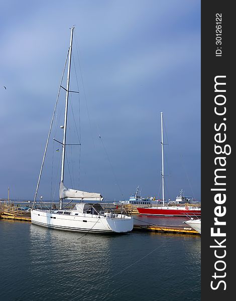 White sailing yacht on an anchor in harbour