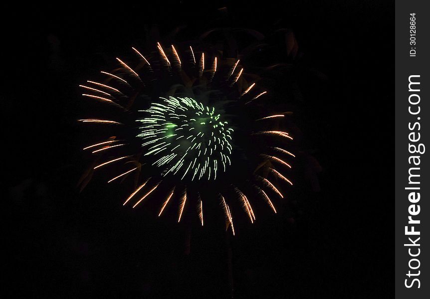 Fireworks formed in a circle of green lights surrounded by a circle of red lights against a black sky. Fireworks formed in a circle of green lights surrounded by a circle of red lights against a black sky