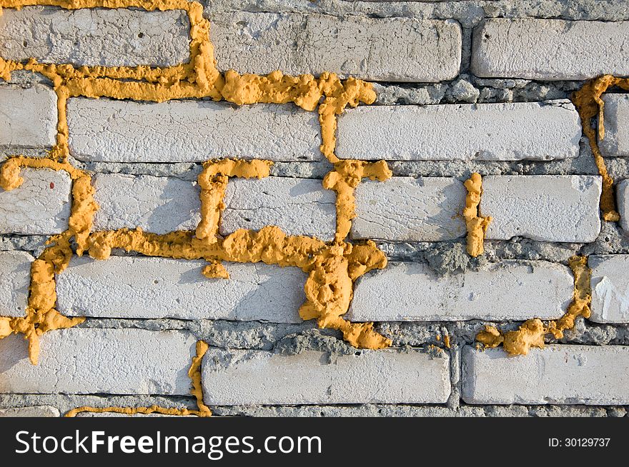 Texture of gray brick wall with a yellow foam. Texture of gray brick wall with a yellow foam.