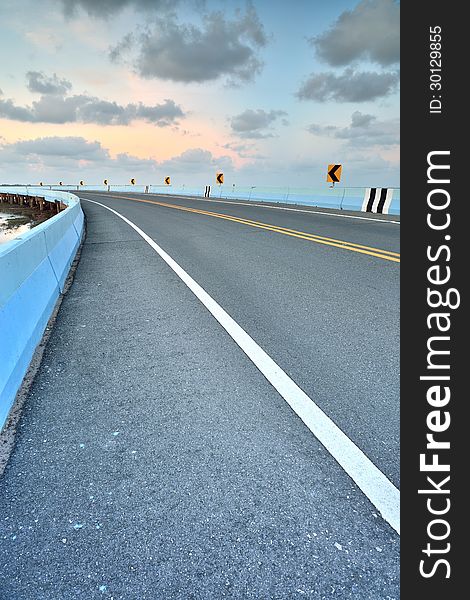 Asphalt road to vertical in cloudy sky