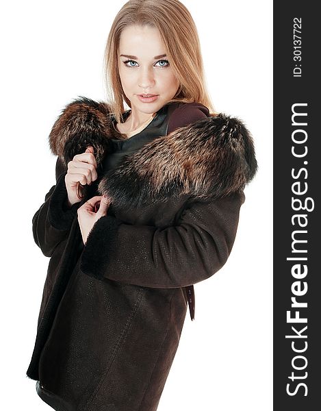 Elegant woman wearing brown sheepskin coat with fur.