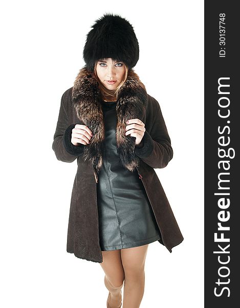 Elegant woman wearing brown sheepskin coat and  hat with fur.